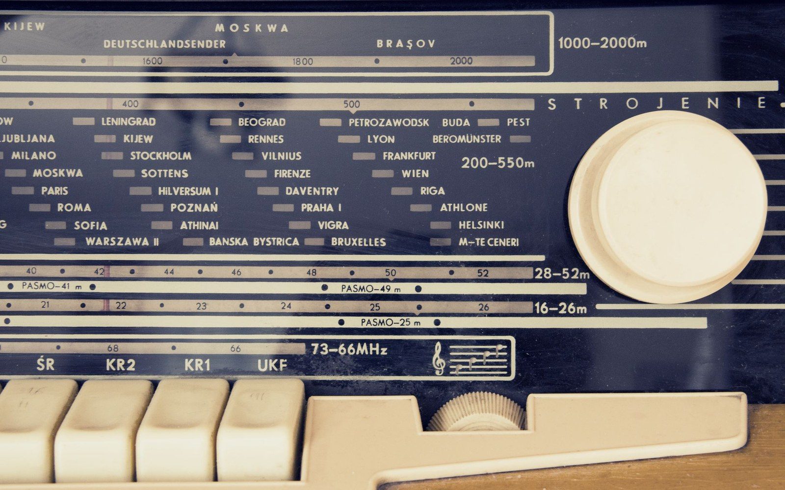A DAB+ tabletop receiver on a domestic kitchen counter, station name displayed on its screen